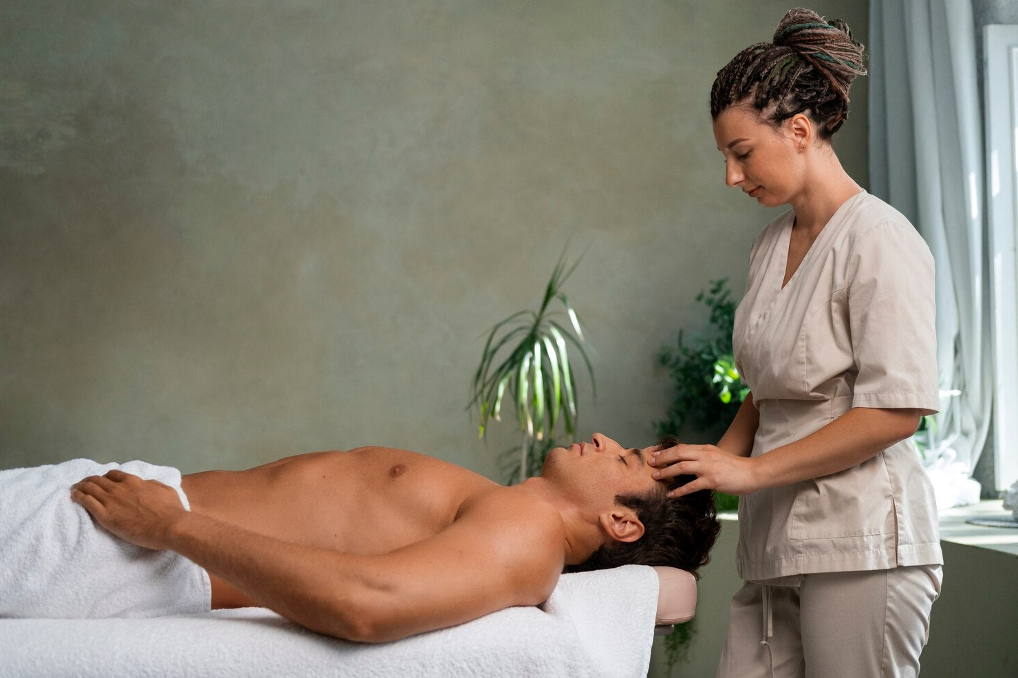 Person receiving a massage from a therapist in a spa setting.