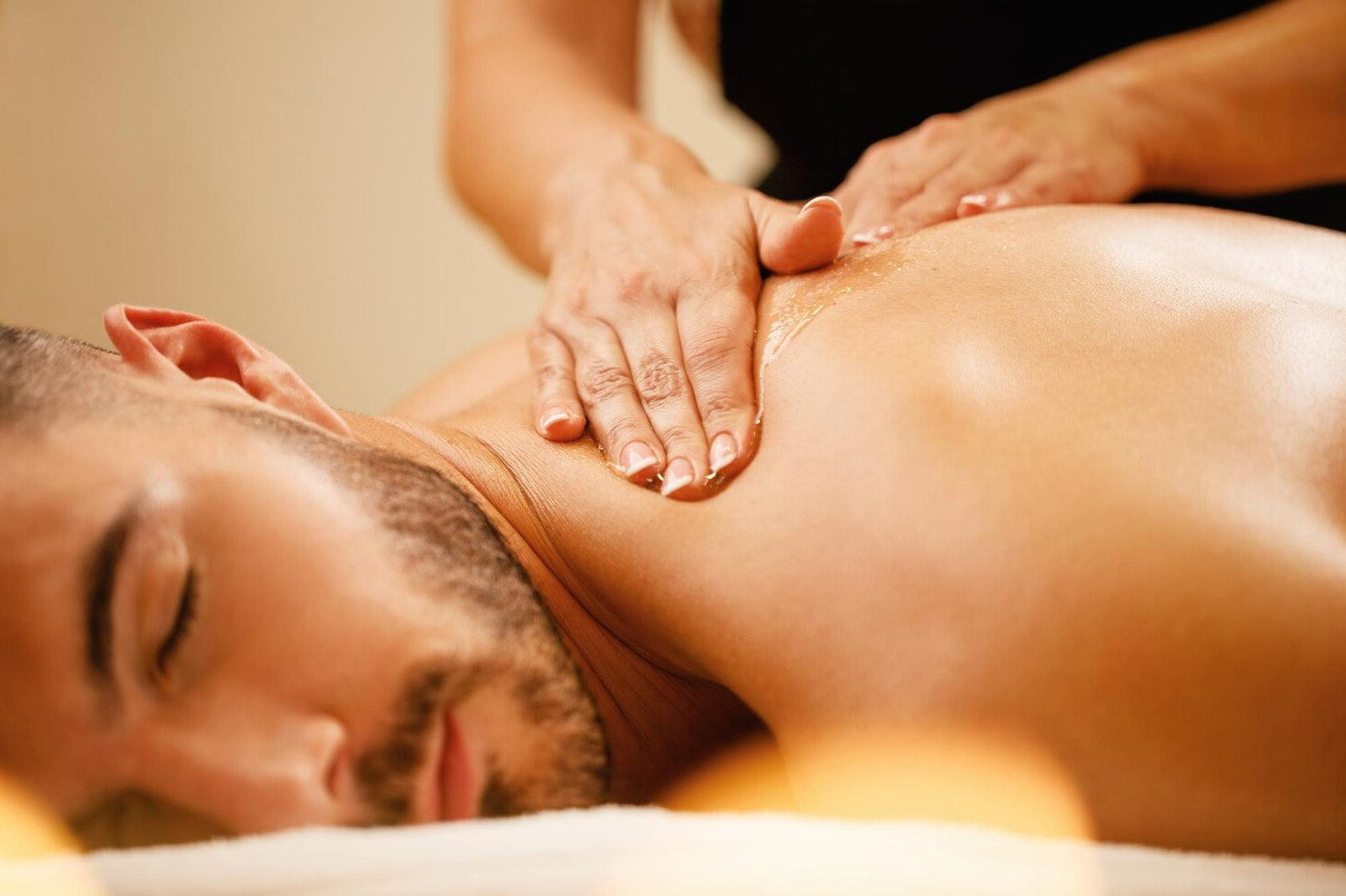 Person receiving a massage with hands applying pressure to the back.
